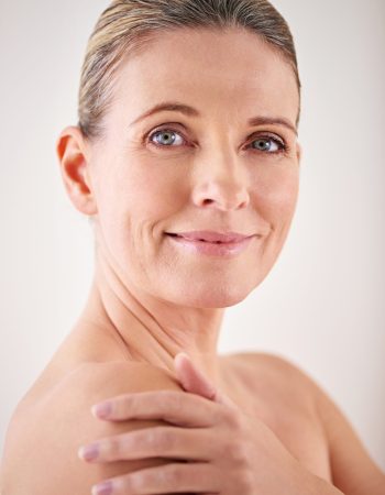 Model, smile and studio with skincare, portrait and cosmetic with treatment. Mature woman, beauty and luxury with body, cosmetics and care for anti ageing and healthy skin for wellness and confidence.