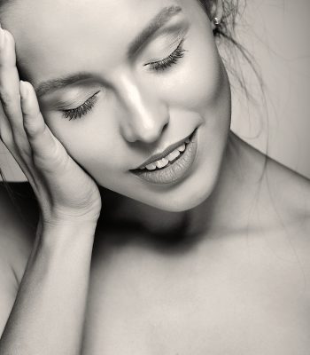 portrait of beautiful woman model with fresh daily makeup and red lips and healthy skin touching her head
