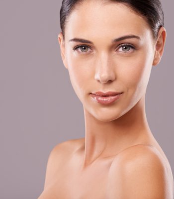 Portrait, woman and glow for makeup, beauty and skincare on mockup studio on grey background. Confident, female person and cosmectics for dermatology, flawless skin and healthy natural aesthetic.