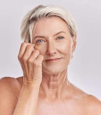 Skincare, health and hair care with a senior woman in studio on a grey background for beauty, skin care and makeup. Face portrait of a happy and healthy model with beautiful and natural hairstyle.