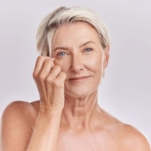 Skincare, health and hair care with a senior woman in studio on a grey background for beauty, skin care and makeup. Face portrait of a happy and healthy model with beautiful and natural hairstyle.