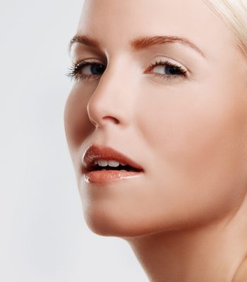 Woman, glow and skincare in studio portrait, foundation and makeup treatment on white background. Female person, dermatology and confidence for shine, smooth skin and facial wellness for cosmetics.